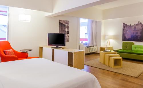 a bedroom with a bed and a tv and a couch at Fiesta Inn Tlalnepantla in Mexico City