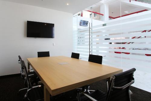 a conference room with a wooden table and chairs at Fiesta Inn Tlalnepantla in Mexico City