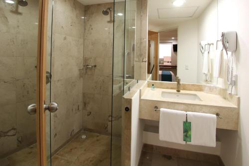 a bathroom with a sink and a glass shower at One Villahermosa 2000 in Villahermosa
