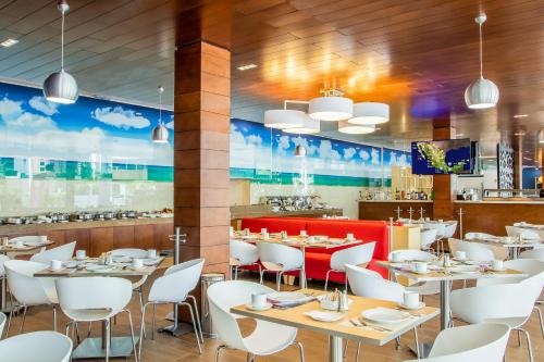 a restaurant with tables and chairs and a bar at Fiesta Inn Playa del Carmen in Playa del Carmen
