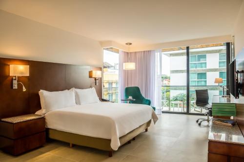 a hotel room with a bed and a balcony at Fiesta Inn Playa del Carmen in Playa del Carmen