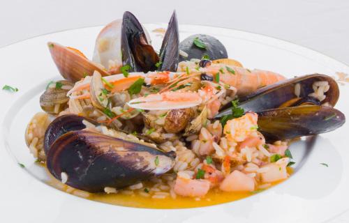 a plate of food with seafood and rice on a plate at La Vigna Hotel in Bonea
