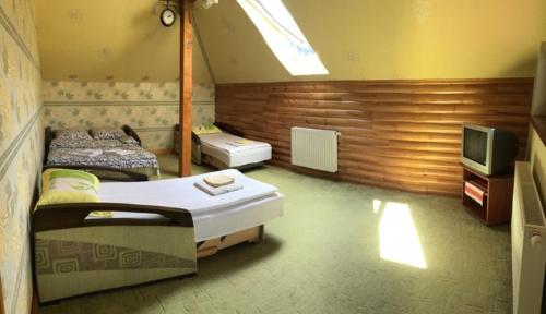 a room with two beds and a television in it at Mansarda Aparts in Skole