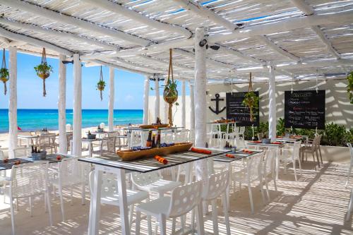 a dining area with tables, chairs and umbrellas at Fiesta Americana Condesa Cancun - All Inclusive in Cancún