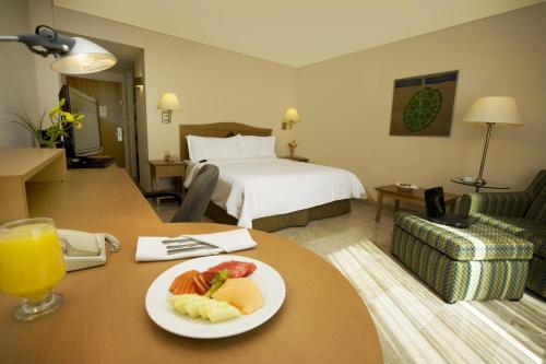 a hotel room with a plate of fruit on a table at Fiesta Inn Ciudad del Carmen in Ciudad del Carmen