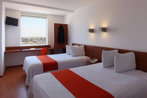 Ein Bett oder Betten in einem Zimmer der Unterkunft One Queretaro Aeropuerto