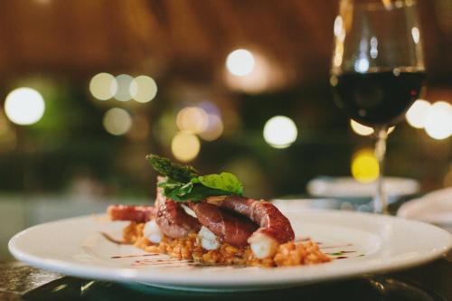 a plate of food on a table with a glass of wine at Fiesta Americana Puerto Vallarta All Inclusive & Spa in Puerto Vallarta