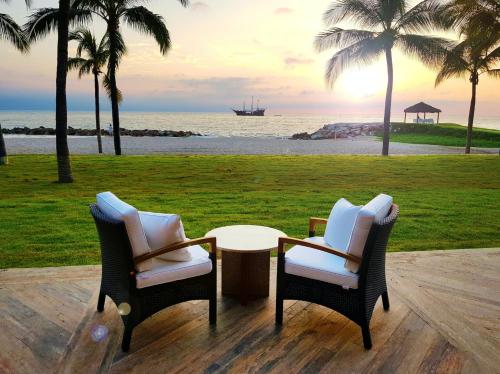 two chairs and a table in front of the beach at Fiesta Americana Puerto Vallarta All Inclusive & Spa in Puerto Vallarta
