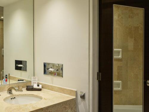 La salle de bains est pourvue d'un lavabo et d'un miroir. dans l'établissement Fiesta Inn Aguascalientes, à Aguascalientes