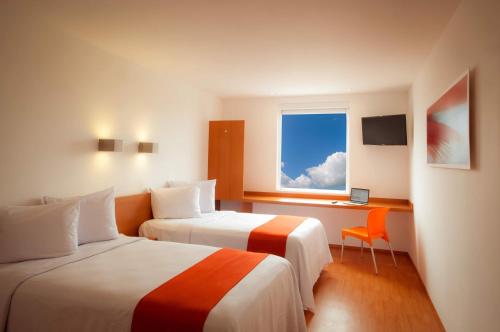 ein Hotelzimmer mit 2 Betten und einem Fenster in der Unterkunft One Monclova in Monclova