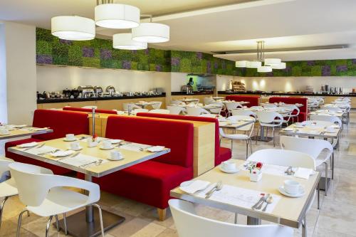un ristorante con tavoli, tavoli e sedie rosse e bianche di Fiesta Inn Centro Historico a Città del Messico