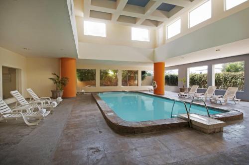 a large swimming pool with chairs and a pool table at Fiesta Inn Hermosillo in Hermosillo