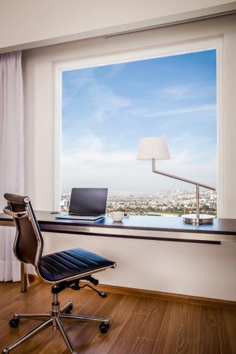 a office with a window and a desk with a laptop at Fiesta Inn Queretaro Centro Sur in Querétaro