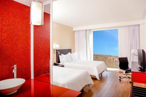 a hotel room with two beds and a window at Fiesta Inn Queretaro Centro Sur in Querétaro