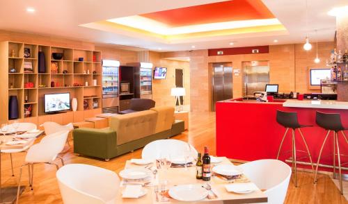 a restaurant with white chairs and a red bar at Fiesta Inn Queretaro Centro Sur in Querétaro