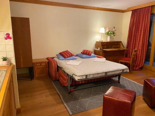 a small bedroom with a bed and a piano at Studio - La Vièze Thermes Park in Val-d'Illiez