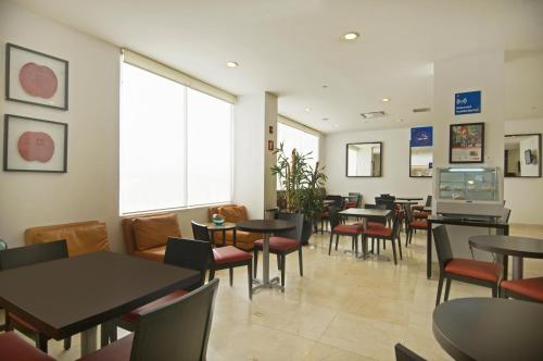 a dining room with tables and chairs in a restaurant at One Toluca Aeropuerto in Toluca