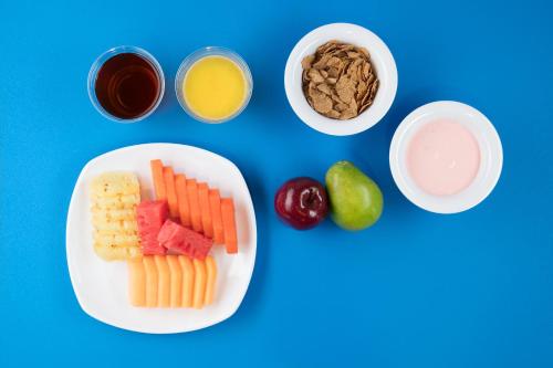 a plate of fruit and vegetables on a blue background at One Toluca Aeropuerto in Toluca