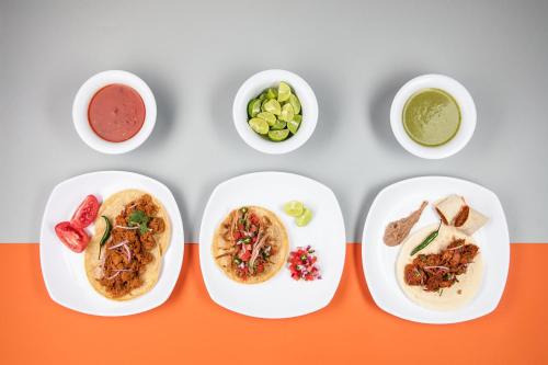 four plates of food with different foods on them at One Toluca Aeropuerto in Toluca
