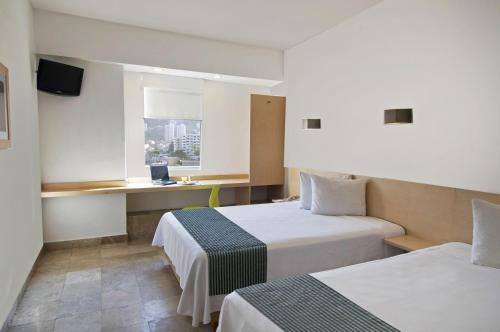 Ένα ή περισσότερα κρεβάτια σε δωμάτιο στο One Aguascalientes Sur