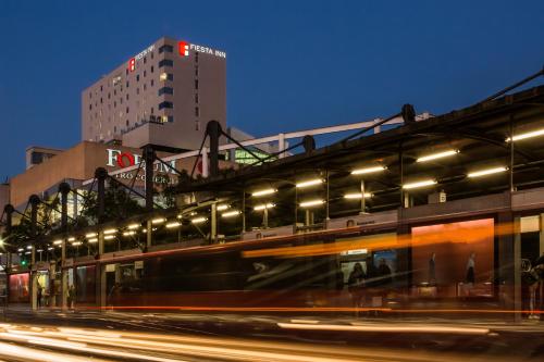 a train speeding past a building at night at Fiesta Inn Express Ciudad de México Forum Buenavista in Mexico City