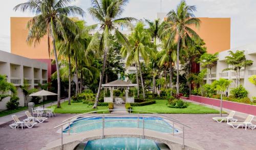 a resort with a swimming pool and palm trees at Gamma Tampico in Tampico