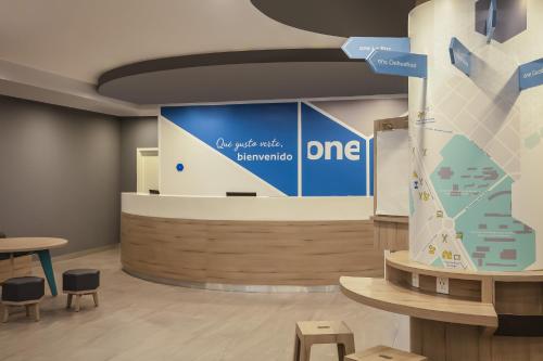 a lobby with a large screen with a one sign at One Monterrey Tecnologico in Monterrey
