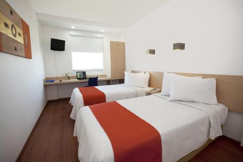 Habitación de hotel con 2 camas y escritorio en One Saltillo Derramadero en La Encantada