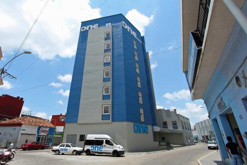ein Gebäude, vor dem ein Polizeiwagen geparkt ist in der Unterkunft One Villahermosa Centro in Villahermosa