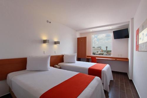 a hotel room with two beds and a window at One Villahermosa Centro in Villahermosa