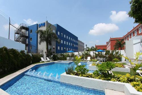une piscine en face d'un hôtel dans l'établissement One Cuernavaca, à Cuernavaca