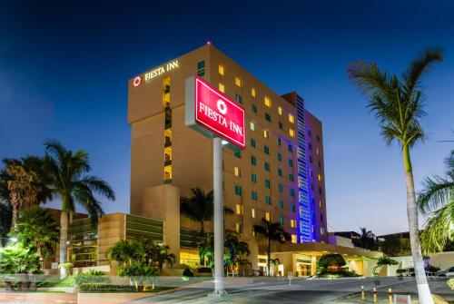 a hotel building with a sign in front of it at Fiesta Inn Tuxtla Gutierrez in Tuxtla Gutiérrez