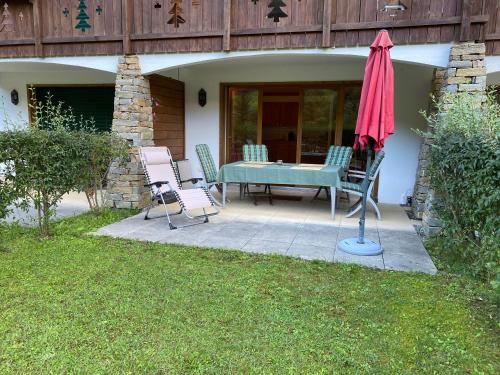 a patio with a table and chairs and an umbrella at Studio - La Vièze Thermes Park in Val dʼIlliez