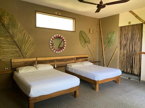a bedroom with two beds and a mirror on the wall at Villas Adriana, Palenque in Palenque