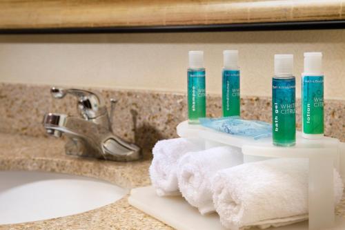 a bathroom counter with toothbrushes and towels on a sink at Holiday Inn Express & Suites San Antonio West Sea World Area by IHG in San Antonio