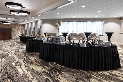 una stanza con tavoli e sedie neri e una stanza con di Holiday Inn Hotel & Suites Des Moines-Northwest by IHG a Urbandale