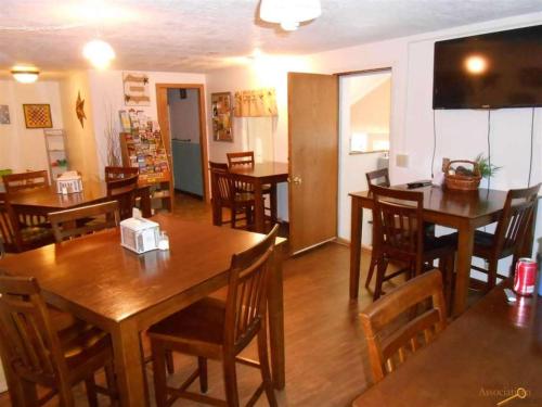 a dining room with wooden tables and chairs at The Brookside Motel / Mt. Rushmore in Keystone
