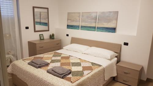 1 dormitorio con 1 cama con 2 almohadas en Apartment Atlantic Roseto Beach, en Roseto degli Abruzzi