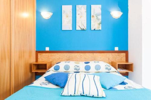 a bed that has a blue blanket on it at LC's Guesthouse in Lagos