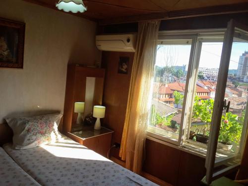 una camera con un letto e una grande finestra di Diana Guesthouse a Veliko Tŭrnovo