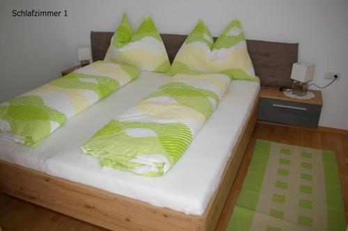 uma cama com almofadas verdes e brancas em Imsterberger Auszeit em Imsterberg