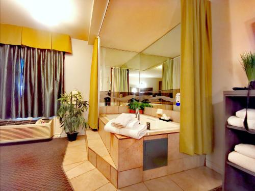 La salle de bains est pourvue d'un grand miroir et d'un lavabo. dans l'établissement Hotel et Motel Le Chateauguay, à Québec