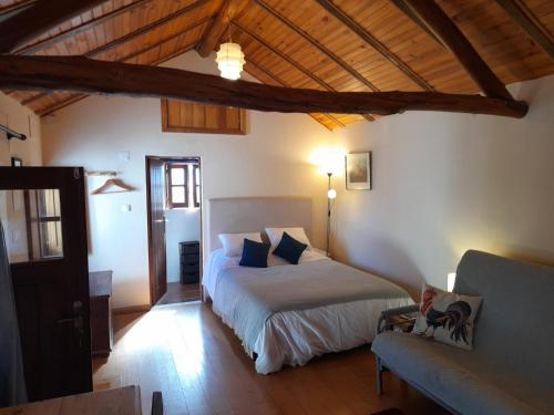 1 dormitorio con 1 cama y 1 sofá en The Cottage near the lake, en Pedrógão Grande