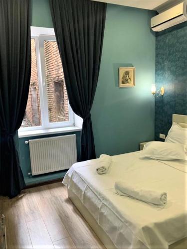 a bedroom with a white bed and a window at Griboedov 13 in Tbilisi City