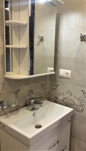 a bathroom with a sink and a mirror at Griboedov 13 in Tbilisi City