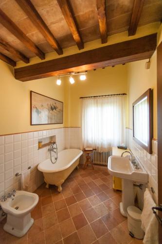 a bathroom with a tub and a toilet and a sink at Podere Piazza Siena in Siena