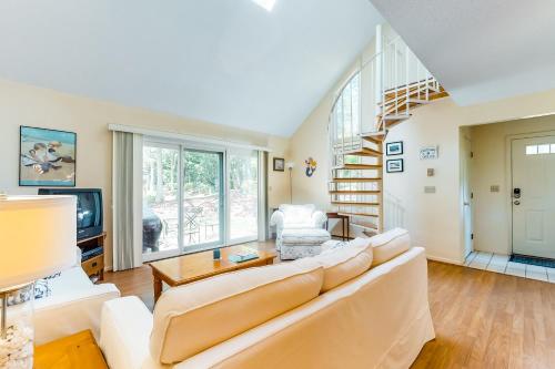 a living room with a large couch and a staircase at Relaxing Cape Getaway in Brewster