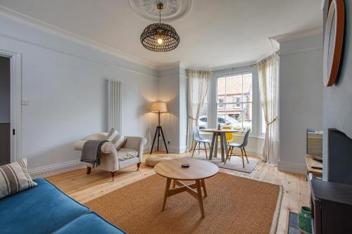 a living room with a blue couch and a table at The Sands Sheringham in Sheringham