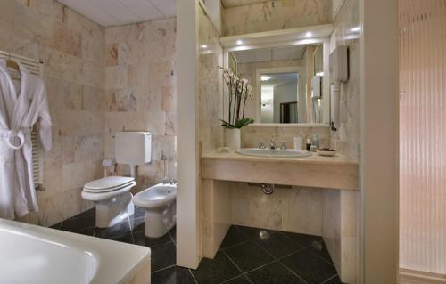 e bagno con lavandino, servizi igienici e vasca. di Hotel Lo Zodiaco ad Abano Terme