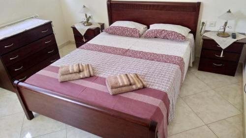 a bedroom with a large bed with two towels on it at Classic-style apartment in Loutra Edipsou